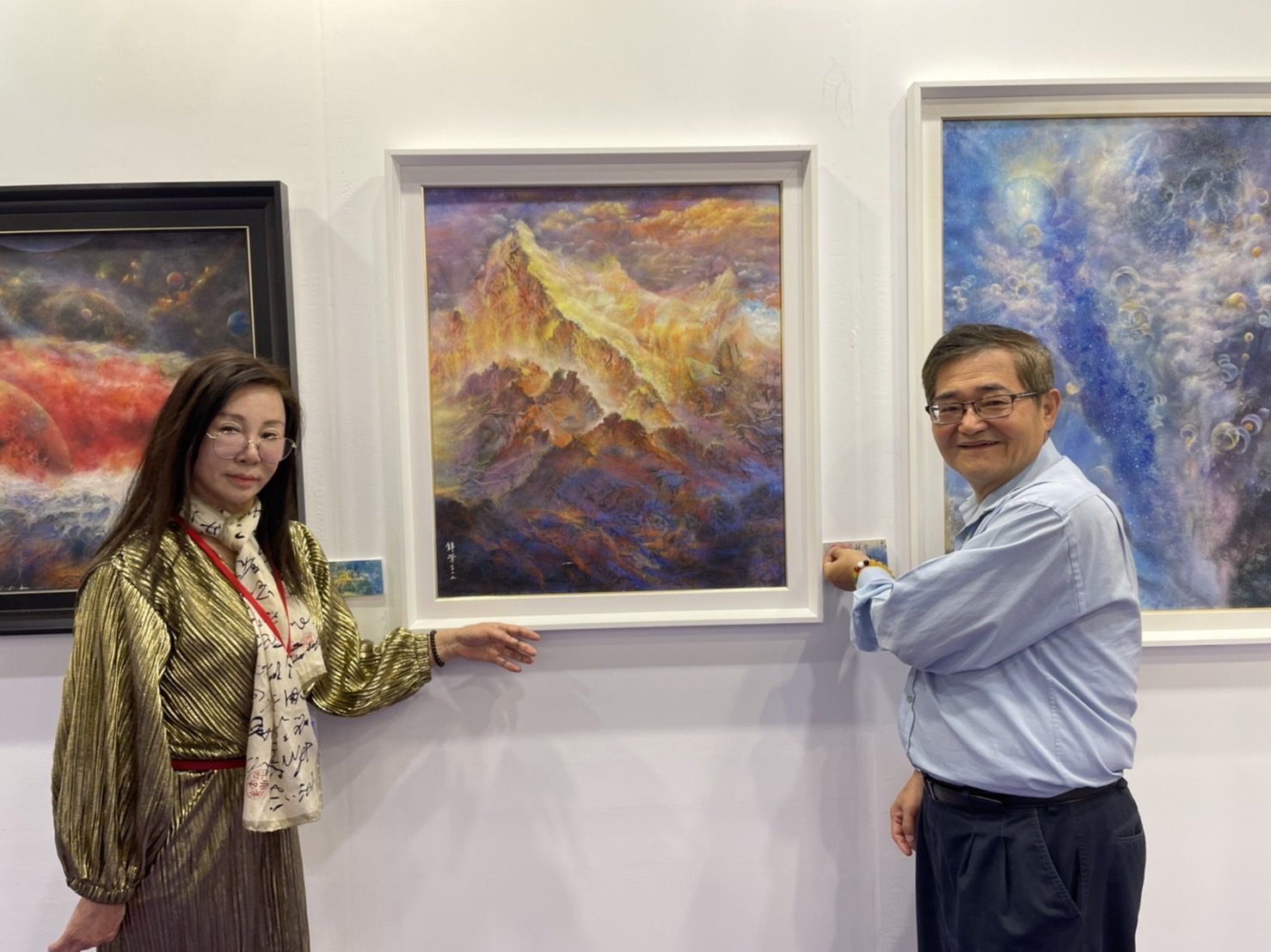 膠彩畫家林錦芳作品背靠金山獲收藏。 膠彩畫家林錦芳（左）以其獨特的「探索宇宙與心靈」系列在台北新藝術博覽會展出。作品「背靠金山」由中國文化大學教授林忠山（右）收藏。
