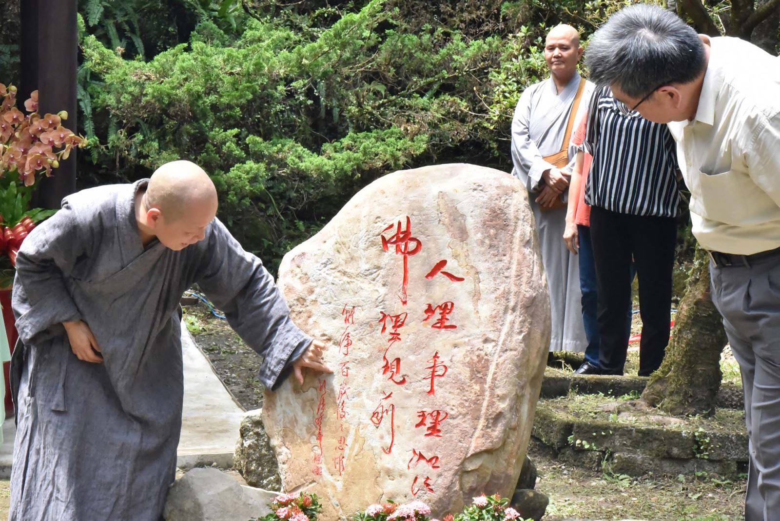 華梵大學董事長悟觀法師（左）介紹人理事理佛理勒石。 