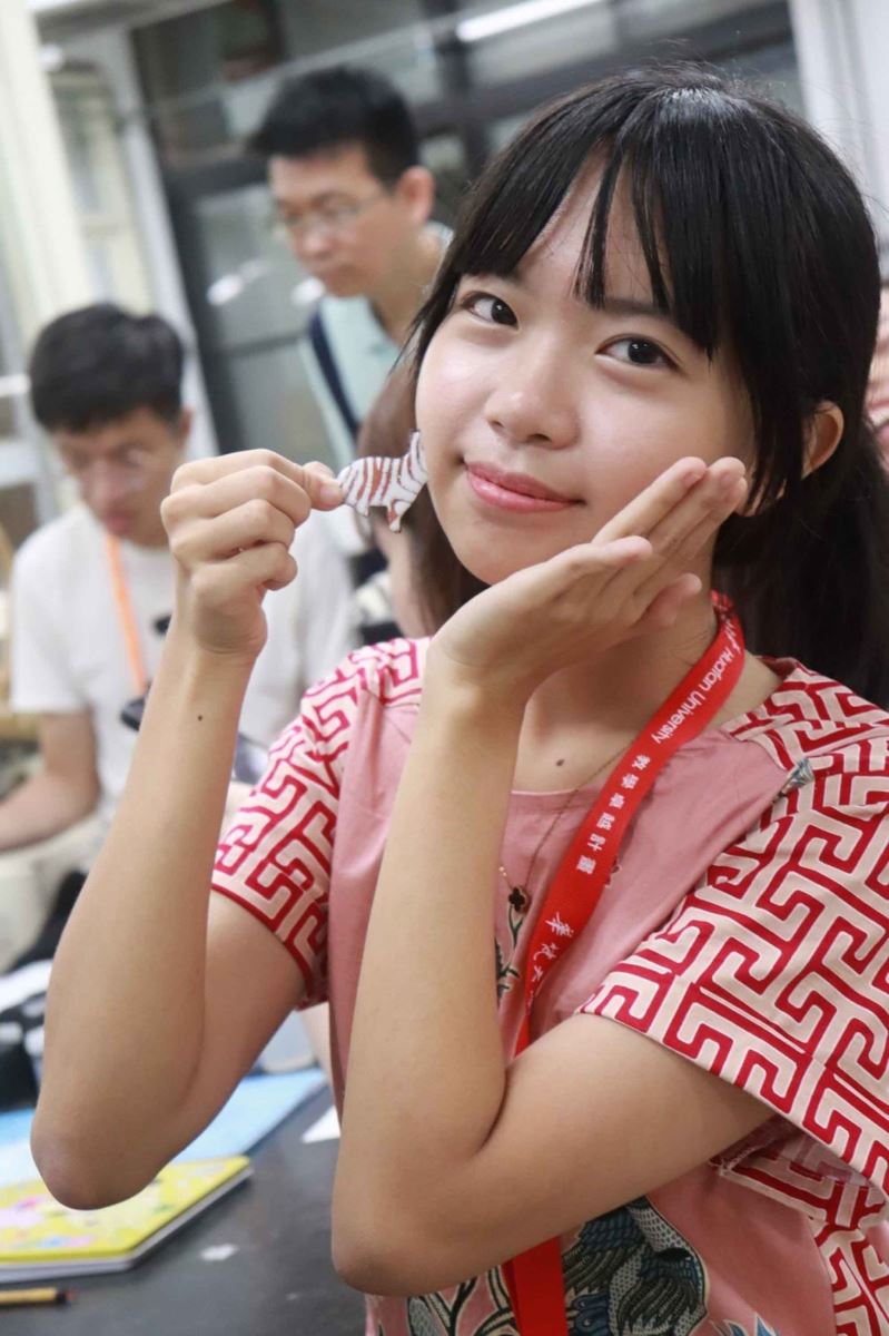 印尼高中生開心秀出自己設計的琺瑯胸針作品。  