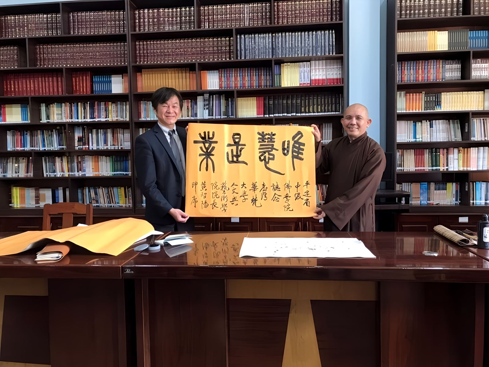 書法名家黃智陽院長（左）贈與墨寶「唯慧是業」給越南平定省中級佛學院校長釋同誠法師